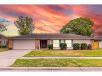 Brick ranch home with attached garage and landscaped lawn at 116 Sheridan Ave, Longwood, FL 32750