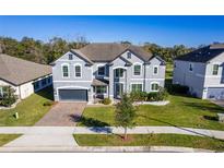 Two-story house with gray exterior, landscaping, and a two-car garage at 1713 Fullers Oak Loop, Winter Garden, FL 34787