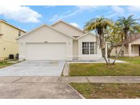 One-story house with a two-car garage and landscaped yard at 1820 Putney Cir, Orlando, FL 32837