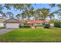 Cute ranch home with a red door and nicely landscaped lawn at 1871 Linden Rd, Winter Park, FL 32792