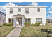 Two-story house with a white exterior, stone accents, and a landscaped lawn at 2655 Trafalgar Blvd, Kissimmee, FL 34758