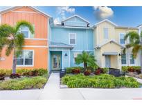 Colorful townhome featuring lush landscaping, and covered entryways for a welcoming curb appeal at 2904 On The Rocks Pt, Kissimmee, FL 34747