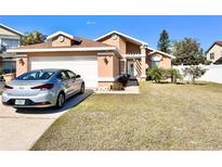 Attractive single-story house with a well-maintained lawn and a two-car garage at 303 Palmview Ct, Kissimmee, FL 34743