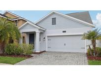 Two-story house with gray siding, a white door, and a two-car garage at 3092 Prelude Ln, Kissimmee, FL 34746