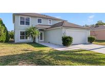 Two-story house with a two-car garage and a well-manicured lawn at 3170 Santa Cruz Dr, Kissimmee, FL 34746