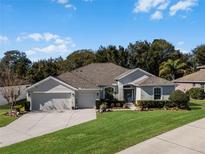 Single-story house with two-car garage, landscaping, and a spacious lawn at 381 Skyview Pl, Chuluota, FL 32766