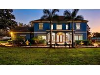 Elegant blue two-story home with a meticulously landscaped front yard and covered entrance at 3943 W Campbell Rd, Lakeland, FL 33810