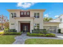 Two-story modern home with gray exterior, dark wood accents, and landscaped lawn at 400 W Hazel St, Orlando, FL 32804