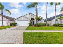 Single-story home with a two-car garage and landscaped front yard at 4705 Pershoie Ln, Kissimmee, FL 34746