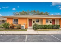 Exterior view of a charming orange condo with well-manicured landscaping at 4944 Tangerine Ave # 4944, Winter Park, FL 32792