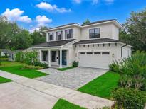 Beautiful two-story home features a brick exterior, well-manicured lawn, dark shutters and trim, and an attached two-car garage at 809 Maxwell St, Orlando, FL 32804