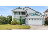 Two-story house with gray siding, teal accents, and a two-car garage at 2119 Victoria Dr, Davenport, FL 33837