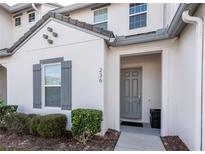 Front view of a two-story townhome with gray door and shutters at 236 Captiva Dr, Davenport, FL 33896