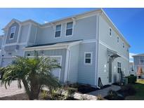 Two-story light blue house with a two-car garage and walkway at 2926 Title St, Kissimmee, FL 34746