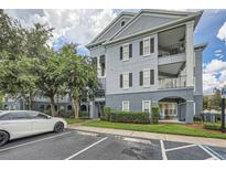 Gray building exterior with balconies, landscaping, and parking at 3621 Conroy Rd # 738, Orlando, FL 32839