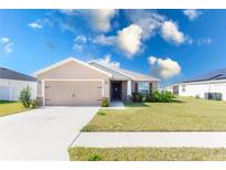 Suburban home with 2-car garage, landscaped lawn and solar panels at 878 Galloway St, Lake Alfred, FL 33850