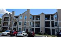 Tan multi-story building with balconies and parking at 2025 Erving Cir # 207, Ocoee, FL 34761