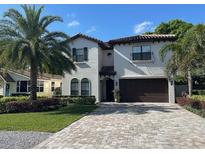 Inviting two-story home with a well-manicured lawn and a tile roof and paver driveway at 205 Hazard St, Orlando, FL 32804