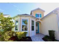 Charming yellow house with bright blue shutters and a neatly landscaped front yard at 240 Blue Starfish Pl, Daytona Beach, FL 32124
