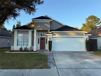 One-story house with a two-car garage and manicured lawn at 371 Lexingdale Dr, Orlando, FL 32828