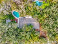 Overhead view of a house with two pools surrounded by lush greenery and mature trees at 9311 University Blvd, Orlando, FL 32817