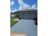 Gray house with a two-car garage and a well-manicured lawn at 212 Ashford Dr, Davenport, FL 33837