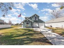 Two-story house with a green exterior, attached garage, and a well-maintained lawn at 2210 Kentucky Derby Dr, Orlando, FL 32825