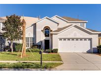 Two-story house with a two-car garage and manicured lawn at 2249 Wyndham Palms Way, Kissimmee, FL 34747