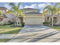 Two-story house with a two-car garage and a landscaped lawn at 2616 Santosh Cv, Kissimmee, FL 34746