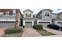 Three-unit townhome complex with attached garages and landscaping at 3656 Brighton Park Cir, Orlando, FL 32812