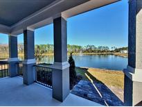 Serene view of a lake with fountain from covered porch at 419 Venetian Palms Blvd, New Smyrna Beach, FL 32168