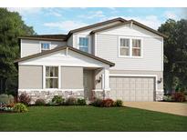 Two-story house with light gray siding, stone accents, and a two-car garage at 4520 Windy Oak Way, St Cloud, FL 34772