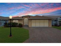 Single-story home with a brick driveway and landscaped lawn at 490 Sweetwater Way, Haines City, FL 33844