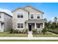 Two-story house with gray siding, a dark door, and a landscaped lawn at 11833 Founders St, Orlando, FL 32832