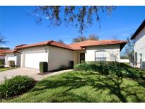 Single-story house with attached garage and manicured lawn at 142 Sandy Point Way, Clermont, FL 34714