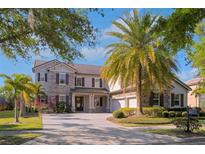 Stunning two-story home boasts stone accents, a paver driveway, lush landscaping and three car garage at 15041 Gaulberry Run, Winter Garden, FL 34787