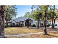 Brick home with mature landscaping and a large driveway at 240 Shady Oaks Cir, Lake Mary, FL 32746