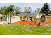 Updated yellow house with solar panels, landscaped yard, and fenced backyard at 2845 Oak Lea Dr, South Daytona, FL 32119