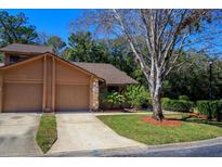 Charming home featuring a two-car garage, well-maintained lawn, and mature landscaping at 596 Albany Pl, Longwood, FL 32779