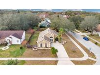 Inviting one story home features mature trees, a long driveway, a well-manicured lawn, and convenient street access at 905 Hatteras Ave, Minneola, FL 34715