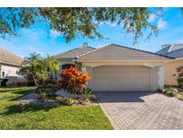 Single-story home with attached garage and well-manicured landscaping at 10812 Woodchase Cir, Orlando, FL 32836