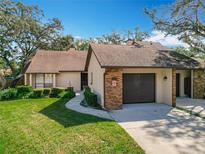 Attractive exterior of a condo with a brown door and attached garage at 123 Golf Club Dr, Longwood, FL 32779