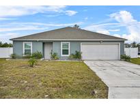 One-story house with a gray exterior, attached garage, and a well-maintained lawn at 139 Violet Ct, Kissimmee, FL 34759