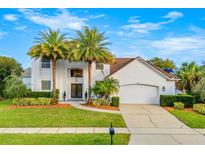 Two-story house with white exterior, palm trees, and landscaped yard at 1706 Tiverton St, Winter Springs, FL 32708