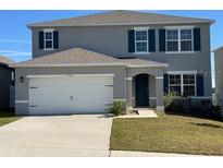 Two-story house with gray siding, white garage door, and landscaped lawn at 1794 Hackberry St, Clermont, FL 34715