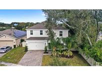 Two-story house with a white exterior, paved driveway, and landscaping at 2041 Brillante Dr, St Cloud, FL 34771