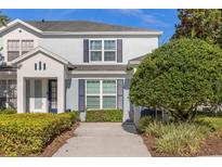 Two-story light blue house with navy blue shutters and landscaped front yard at 2546 Renshaw St, Kissimmee, FL 34747