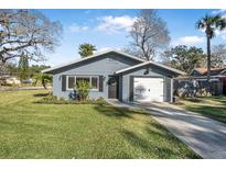 Gray house with white garage door and green lawn at 300 S Brighton Dr, Port Orange, FL 32127