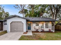 Charming house exterior featuring a gray and white color scheme, a welcoming front porch, and a neatly landscaped yard at 3012 Amherst Ave, Orlando, FL 32804