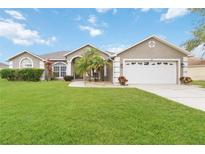 One-story house with attached two-car garage and a spacious lawn at 3418 Gator Bay Creek Blvd, St Cloud, FL 34772